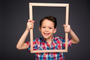  image of boy holding frame around his face